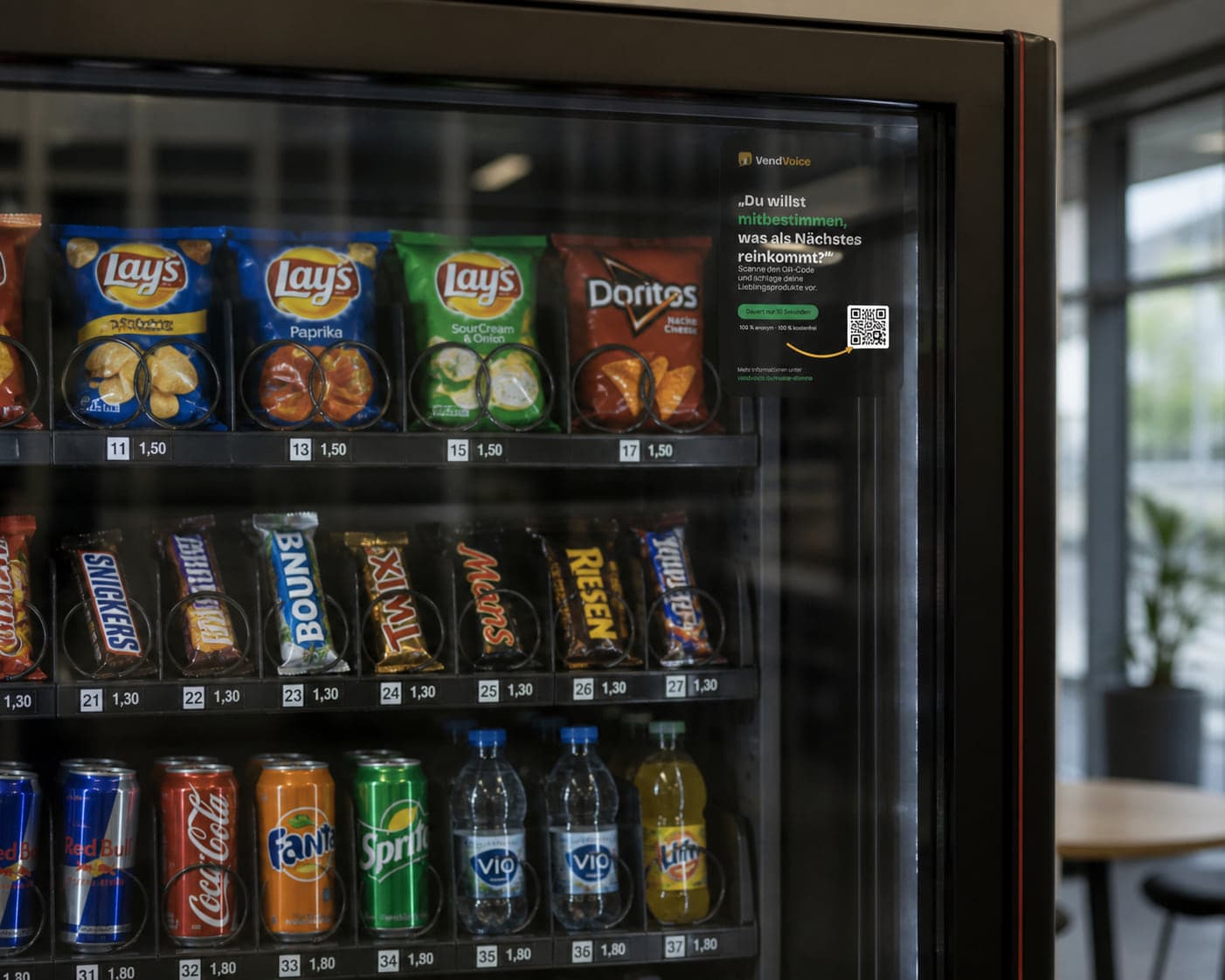 VendVoice-QR-Sticker auf der Frontscheibe eines gefüllten Snack- und Getränkeautomaten: „Du willst mitbestimmen, was als Nächstes reinkommt?“ mit QR-Code